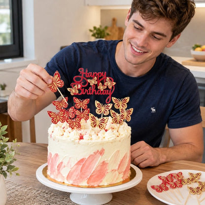 Décoration gateau anniversaire   Homme décore gâteau avec motif papillon rouge