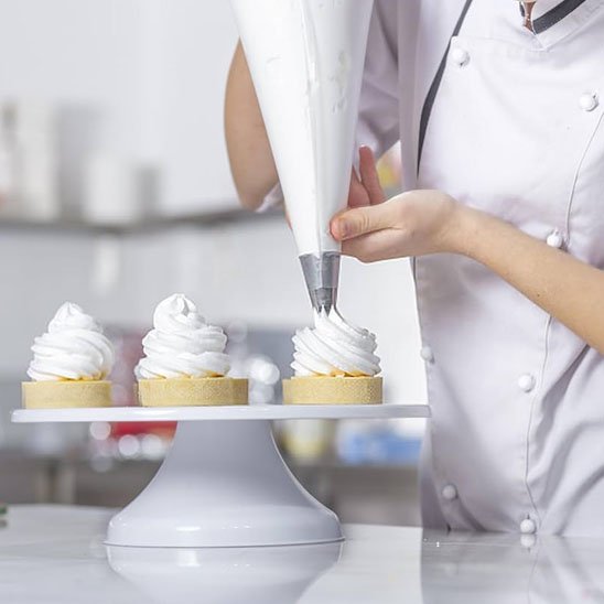 Douille patisserie  avec multiple décorattion de muffins avec de pate de couleur blanche.