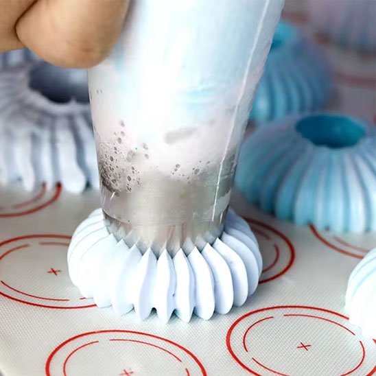 Douille patisserie connectée avc un motif floral blanc pour la pâte mole sur un tapis de cuisson