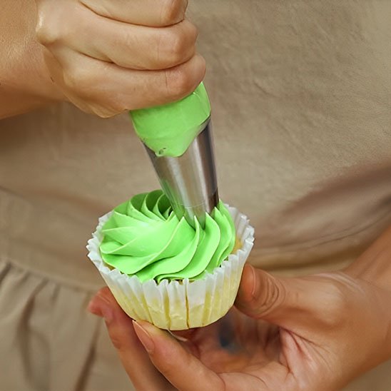 Douille patisserie  decore un muffin avec la pate verte.