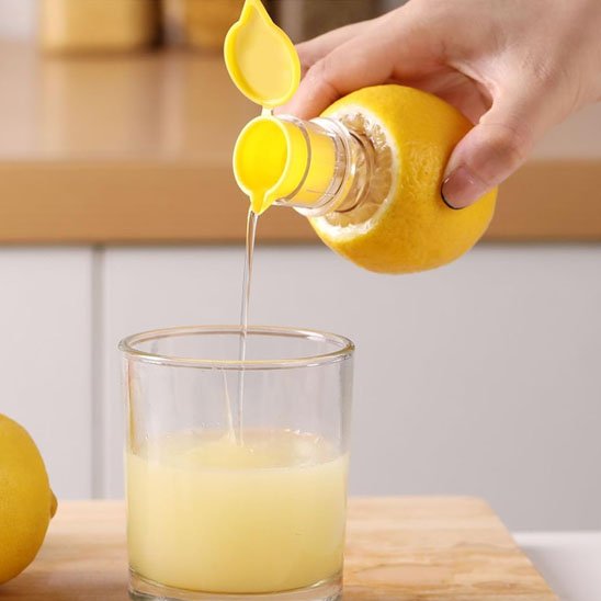  Jus citron versé dans un verre avec Presse agrume 