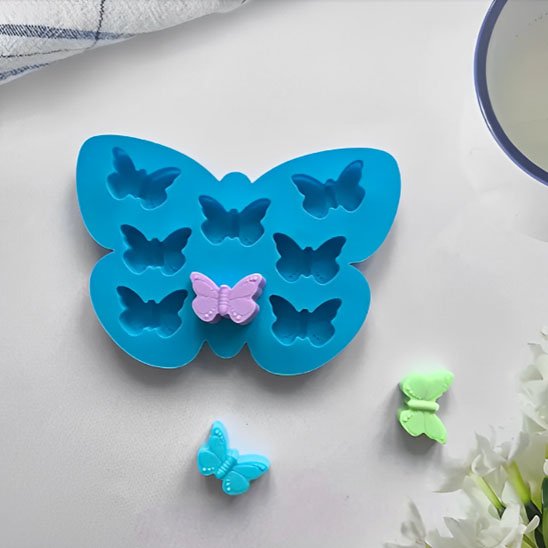 Présentation Moule à gateau bleu foncé  et trois differents petits gâteaux en forme de papillon