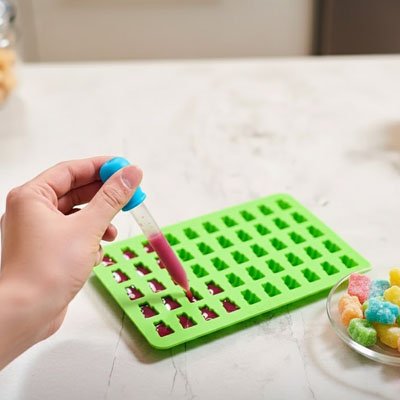 Remplissage de Moules en silicone vert de gélifiant  rouge avec une compte-goutte