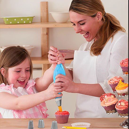  Une femme et sa fille décorent  un capcake avec Douille patisserie connectée à la poche à douille bleue Une 